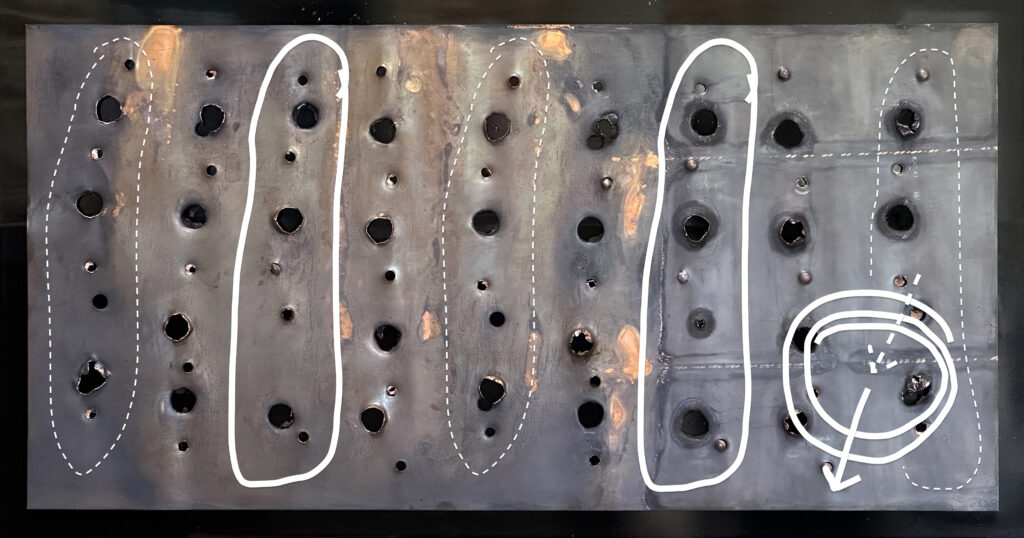 A sheet of copper with large drill holes in a row