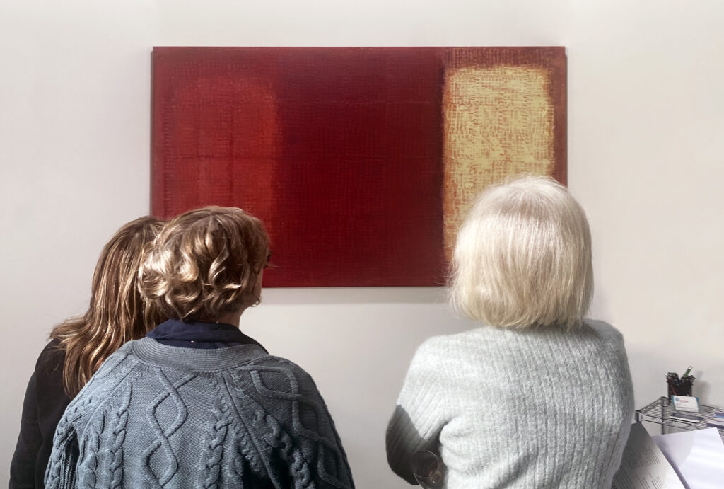 Exhibition opening showing tree people looking at the art on display